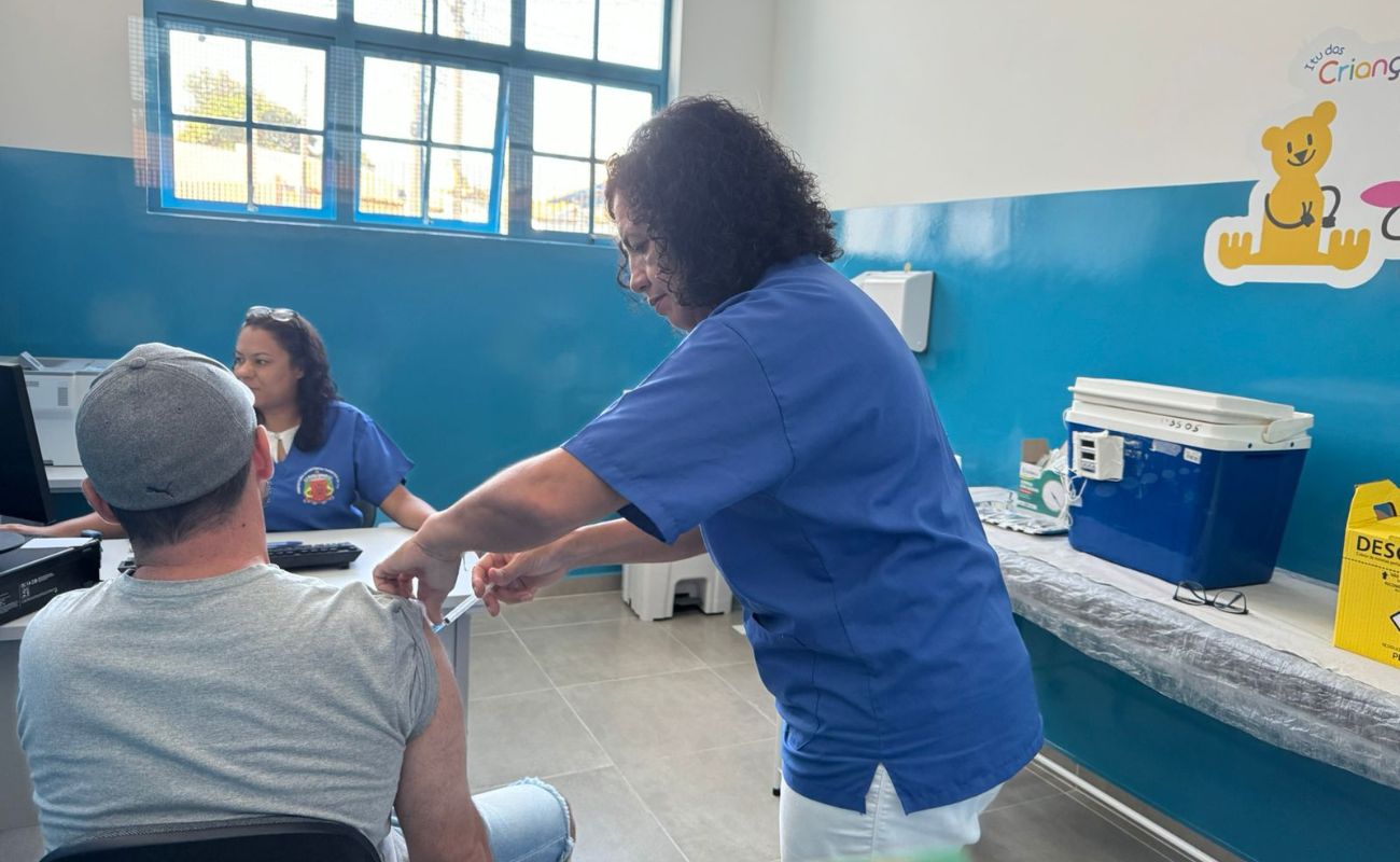 Imagem mostra um munícipe em momento de vacinação, onde a enfermeira está aplicando a dose.