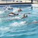 Imagem mostra alunos nadando na piscina do estádio, em momento de aulas de natação e hidroginástica.