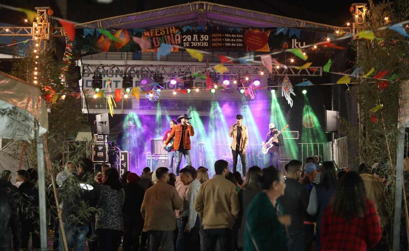 Imagem mostra uma das atrações se apresentando no palco da festa junina.