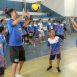 Imagem mostra o ex-atleta olímpico Maurício Lima levantando a bola de volei para uma das crianças participantes do evento.